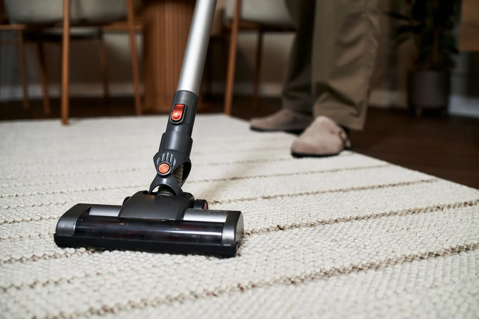 Vacuuming a striped area rug during a house cleaning visit in Douglas County